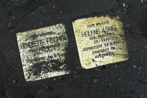 Germany Holocaust Footpaths Picture taken July 1, 2010 shows the so called 'Stolpersteine', or stumbling stones by German artist Gunter Demnig of Holocaust victims Henriette Fischer and Helene Asriel set into Genthiener Strasse street in Berlin, Germany. Demnig has set more than 25,000 of these stumbling stones which are shiny brass plaques in the size of a child's hand and which mark the lives of people lost to the Nazis between 1933 and 1945, fixed in front of places were they once lived before they were killed in the Holocaust. One of the stones reads "Davisco Asriel lived here. Born in 1882. Deported 25.1.1942. Murdered in Riga." Artist Demnig said "It's a social sculpture and if you look at it as a whole, it is the biggest art monument in the world." (AP Photo/Markus Schreiber)