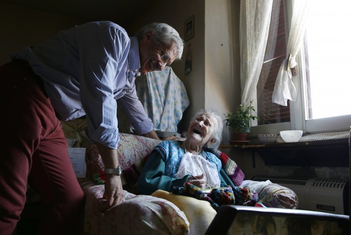 In this Friday, June 26, 2015 photo, Emma Morano, 115, smiles at her physician, Carlo Bava, in her apartment in Verbania, Italy. Morano and Susannah Mushatt Jones, also 115, of the Brooklyn borough of New York, are believed to be the last two people in the world with birthdates in the 1800s. (AP Photo/Antonio Calanni)