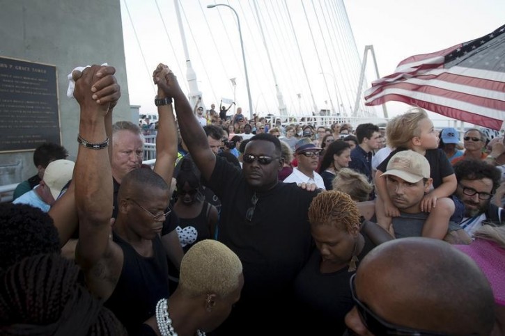 A crowd of people hold hands as they meet atop the Arthur Ravenel Jr. bridge in Charleston, June 21, 2015.  Reuters