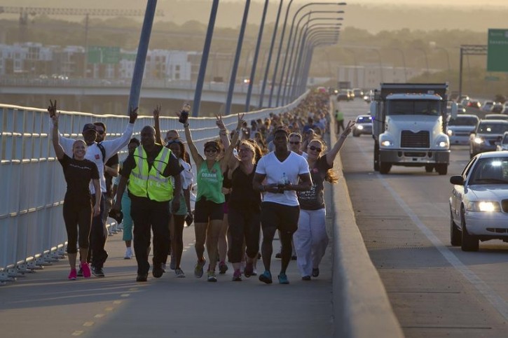 People walk in solidarity along the Arthur Ravenel Jr. bridge in Charleston, June 21, 2015, after the first service at the Emanuel African Methodist Episcopal Church since a mass shooting left nine people dead. Hundreds of people packed the sweltering Emanuel African Methodist Episcopal Church in Charleston for an emotional memorial service on Sunday just days after a gunman, identified by authorities as Dylann Roof, a 21-year-old white man, shot dead nine black church members.   REUTERS/Carlo Allegri