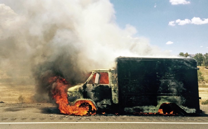 In this photo provided by Jay Rutherford, smoke rises from a burning truck packed with fireworks after it exploded on Interstate 15 near Ivanpah, Calif., close to the Nevada state line Thursday, July 2, 2015. The Chevrolet box van had ignited shortly before 1:30 p.m., burning to the ground and clogging the main artery between Los Angeles and Las Vegas for hours. (Jay Rutherford via AP)