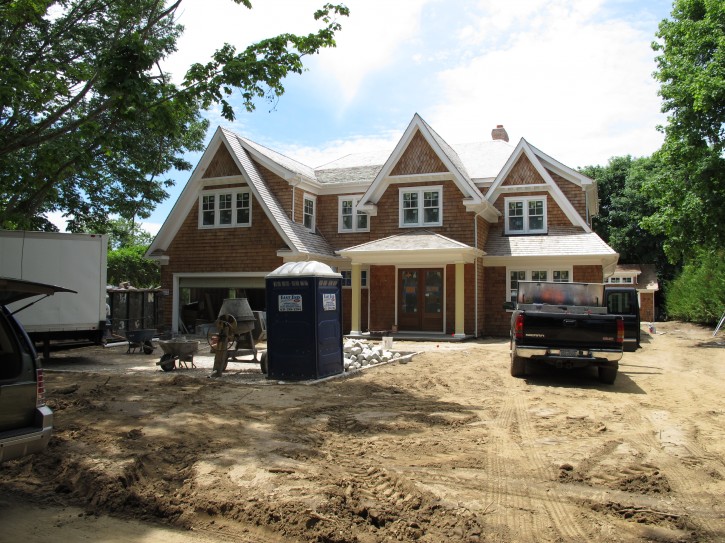 In this photo taken Thursday, June 25, 2015, in Southampton, N.Y., construction work continues on a new home just blocks from the village's downtown shopping district. Southampton is among the villages in the Hamptons considering size limits for building on small lots. (AP Photo/Frank Eltman)