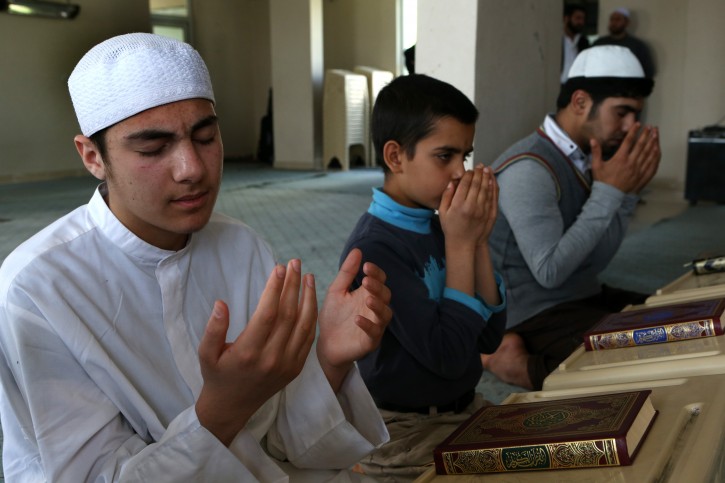 In this April 19, 2015 picture, young Syrians pray as they attend a religious class at an Islamic teaching center designed to counter Islamic State group indoctrination, near the Turkish-Syrian border city of Sanliurfa, southern Turkey. (AP Photo/Hussein Malla)