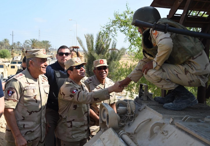 In this picture provided by the office of the Egyptian Presidency, Egyptian President Abdel-Fattah el-Sissi, center, greets members of the Egyptian armed forces in Northern Sinai, Egypt, Saturday, July 4, 2015.  Egyptian President Abdel-Fattah el-Sissi has traveled to the troubled northern part of the Sinai Peninsula to inspect troops, after Islamic State-linked militants struck a deadly blow against the military this week in a coordinated assault. (Egyptian Presidency /Mohammed Abdel-Muati via AP)