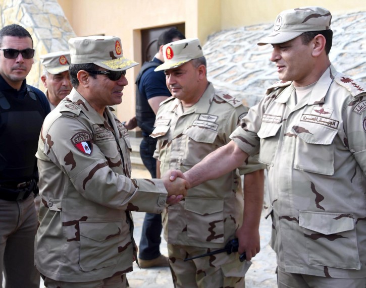 In this picture provided by the office of the Egyptian Presidency, Egyptian President Abdel-Fattah el-Sissi, second left, greets members of the Egyptian armed forces in Northern Sinai, Egypt, Saturday, July 4, 2015.  Egyptian President Abdel-Fattah el-Sissi has travelled to the troubled northern part of the Sinai Peninsula to inspect troops, after Islamic State-linked militants struck a deadly blow against the military this week in a coordinated assault. (Egyptian Presidency /Mohammed Abdel-Muati via AP)