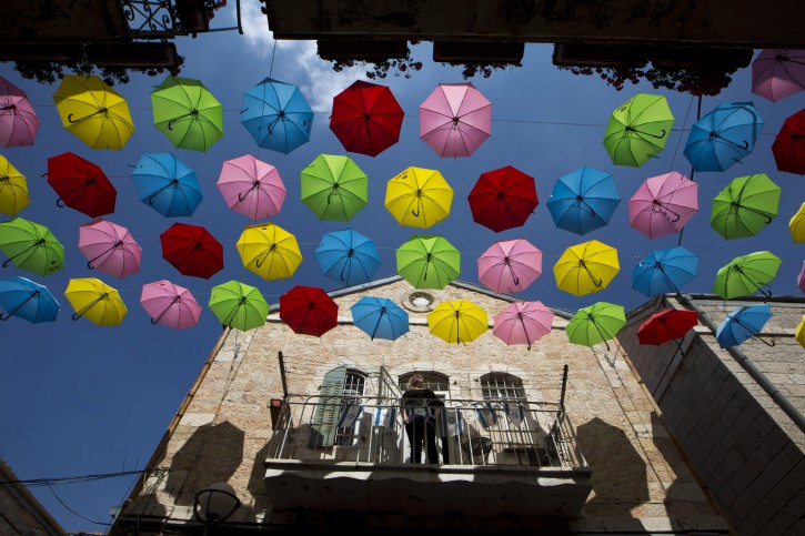 Colorful umbrellas are suspended over a central street in downtown Jerusalem, Israel, 30 June 2015. Around 1,000 umbrellas were placed by the  Jerusalem municipality in order to decorate the street ahead of summer events.  EPA/ABIR SULTAN