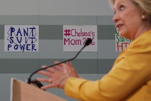 Hillary Clinton answers a reporter's question in front of a sign reading "Pant Suit Power" following a town hall campaign stop in Nashua, New Hampshire July 28, 2015. REUTERS/Brian Snyder