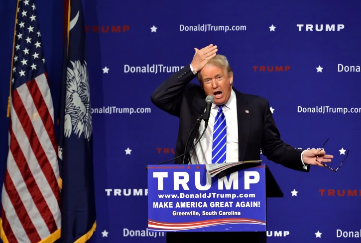 Republican presidential candidate Donald Trump pulls his hair back to show that it is not a toupee while speaking during a rally at the TD Convention Center, Thursday, Aug.  27, 2015, in Greenville, S.C. Trump says his trademark hairdo is for real. He told 1,800 people in South Carolina Thursday: "It's my hair ... I swear." (AP Photo/Richard Shiro)