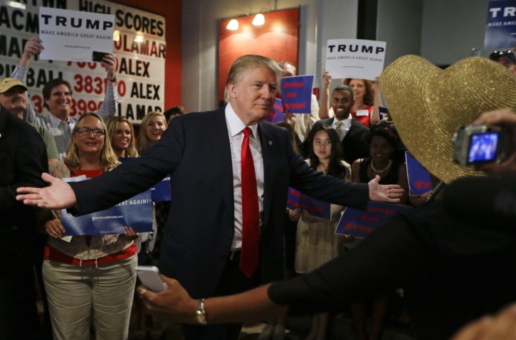 Republican presidential candidate Donald Trump reaches out to hug a supporter after he spoke at the National Federation of Republican Assemblies on Saturday, Aug. 29, 2015, in Nashville, Tenn. (AP Photo/Mark Humphrey)