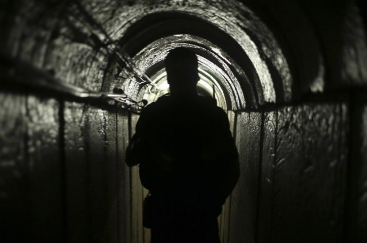 FILE - A Palestinian fighter from the Izz el-Deen al-Qassam Brigades, the armed wing of the Hamas movement, is seen inside an underground tunnel in Gaza August 18, 2014.  Reuters