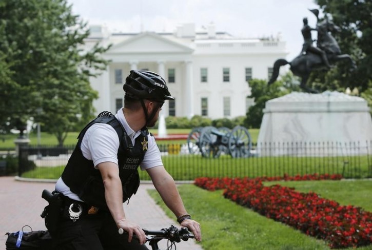 A U.S. Secret Service uniformed police officer  looks back at the White House during a bomb threat in Washington June 9, 2015. REUTERS/Gary Cameron 