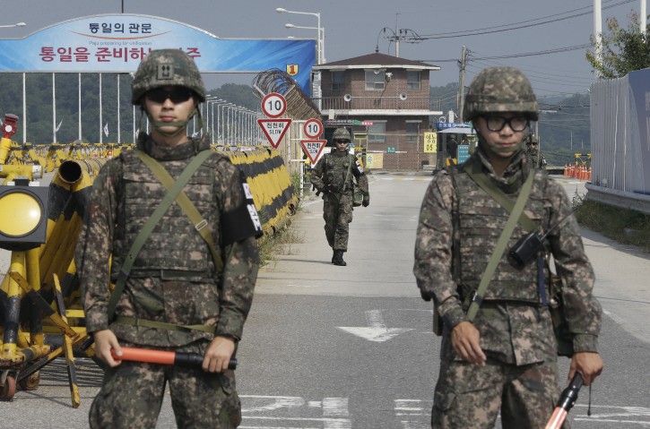 A South Korean amy soldier walks as his colleague soldiers stand guard on Unification Bridge, which leads to the demilitarized zone, near the border village of Panmunjom in Paju, South Korea, Sunday, Aug. 23, 2015.  AP