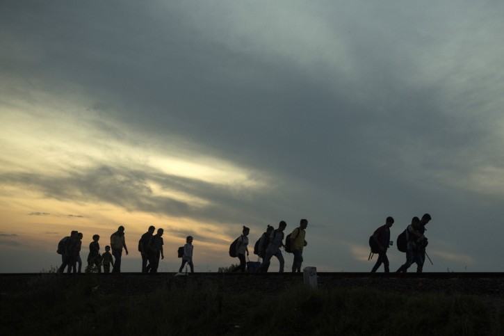 FILE - This is a Thursday Sept. 3, 2015 file photo of a group of refugees as they walk along the railway tracks near the town of Roszke, Hungary, after crossing the border from Serbia. Among the tens of thousands fleeing war and despair in the Middle East, one group feels a special relief in reaching Europe: those who have escaped areas ruled by Islamic State extremists and the harsh scrutiny of their religious police.  (AP Photo/Santi Palacios, File)
