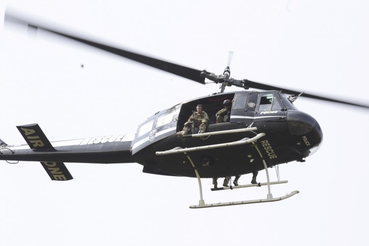 A police helicopter patrols a swampy area near route 59 and Rollins in Fox Lake, Ill.,  where a manhunt is in progress after an officer was shot on Tuesday, Sept. 1, 2015.  Lake County Major Crimes Task Force Cmdr. George Filenko says an officer was shot Tuesday morning in Fox Lake, 55 miles north of Chicago.  (Stacey Wescott/Chicago Tribune via AP) 