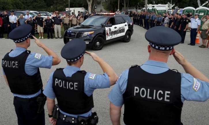 FILE  -Police officers salute at a vigil for slain Fox Lake Police Lieutenant Charles Joseph Gliniewicz in Fox Lake, Illinois, United States, September 2, 2015.  Reuters