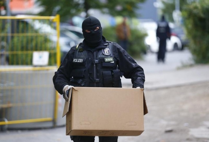 A German special police member carries out items secured during a raid at a mosque association property in Berlin, Germany September 22, 2015. German police said they raided eight properties in Berlin early on Tuesday that they believe are being used by suspected Islamists supporting fighting in Syria. REUTERS