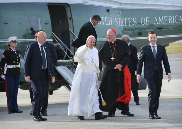 Escorted by Cardinal Timothy Dolan (C-R) of the Archdiocese of New York, Pope Francis waves to the hundreds of faithful who came to see him off as he prepared to depart John F. Kennedy International Airport in New York September 26, 2015. REUTERS/John Paraskevas/Pool