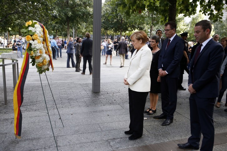 German Chancellor Angela Merkel places a wreath next to the Survivor Tree at the 9/11 Memorial, Saturday, Sept. 26, 2015, in New York. (AP Photo/Jason DeCrow)
