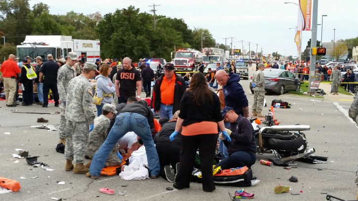 Emergency personnel and spectators respond after a vehicle crashed into a crowd of spectators during the Oklahoma State University homecoming parade, causing multiple injuries, on Saturday, Oct. 24, 2015 in Stillwater, Oka.  (David Bitton/The News Press via AP) 