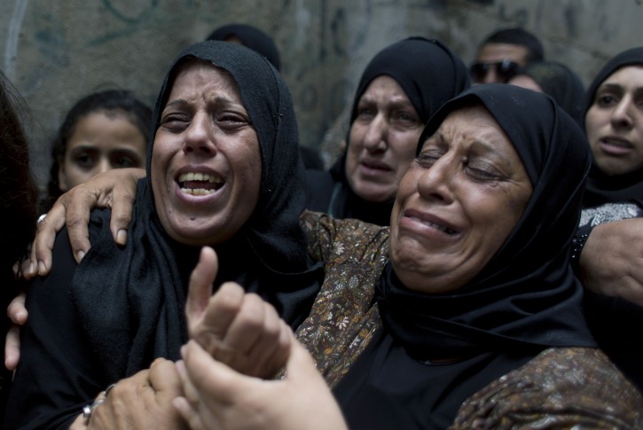 Palestinian Dalal Abeidallah, left, mother of 13 year old, Abdel Rahman Shadi, who died after being hit by a live bullet to the chest after throwing a stone at Israeli army soldiers, cries while being comforted by mourning relatives during her son's funeral procession, at Aida Refugee camp, in the West Bank city of Bethlehem, Tuesday, Oct. 6, 2015. Israeli Prime Minister Benjamin Netanyahu warned Monday that he will use a "strong hand" to quell violent Palestinian protests and deadly attacks, signaling that the current round of violence is bound to escalate at a time when a political solution to the conflict is increasingly distant. (AP Photo/Nasser Nasser)