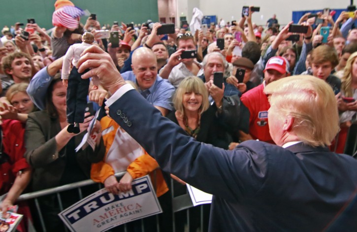 Republican presidential candidate Donald Trump holds a doll of himself before signing it for a fan Monday, Oct. 19, 2015, in Anderson, S.C. (Ken Ruinard/The Independent-Mail via AP) 