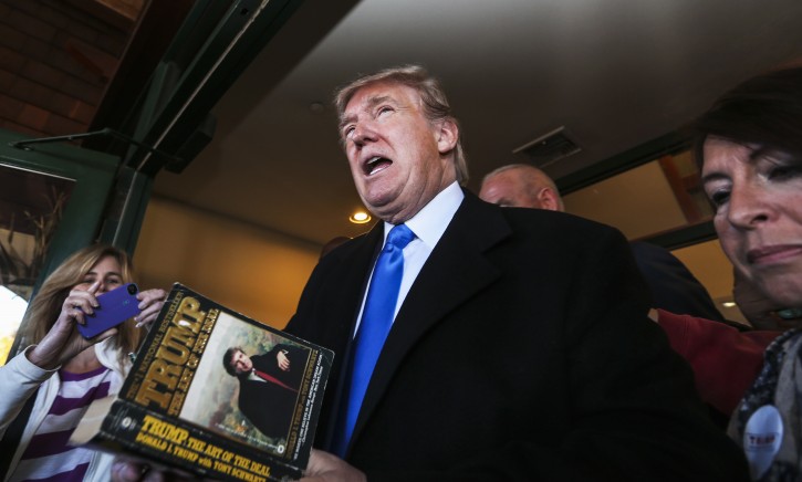 Republican presidential candidate Donald Trump autographs a book on his way out after speaking at a town hall meeting at the Atkinson Country Club in Atkinson, N.H., Monday, Oct. 26, 2015.  (AP Photo/Cheryl Senter)