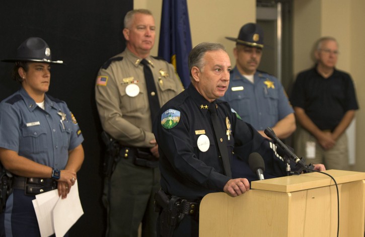Roseburg Police Chief Jim Burge, center, talks about his officers involvement in the shooting the morning of the mass murder at Umpqua Community College during press conference in Roseburg, Ore., Wednesday, Oct. 7, 2015. (Chris Pietsch /The Register-Guard via AP) 
