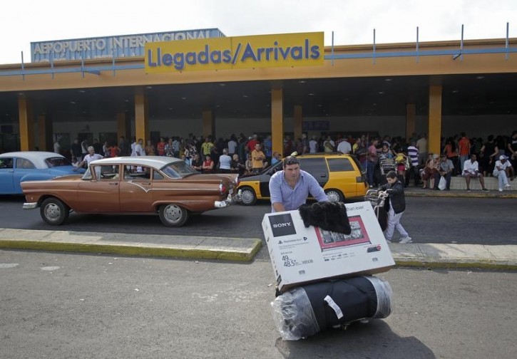 FILE - A passenger pushes a luggage cart after arriving on a charter flight from Tampa, Florida, at the airport in Havana January 15, 2015. Reuters