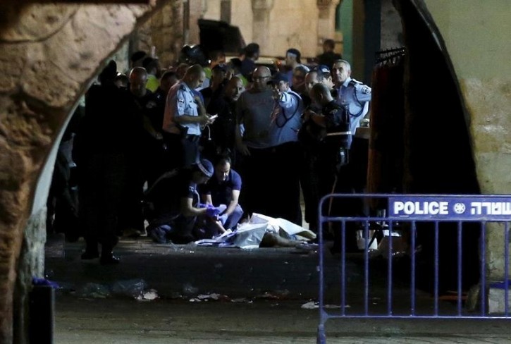 Israeli security personnel stand next to the body of a Palestinian man who was shot dead after he stabbed and killed two people in Jerusalem's Old City October 3, 2015. A Palestinian man stabbed and killed two people in Jerusalem's Old City on Saturday before police shot him dead, officers said, amid an uptick in violence in the city and occupied West Bank. Palestinian militant group Islamic Jihad issued a statement claiming the attacker as one of its members. REUTERS/Ammar Awad 