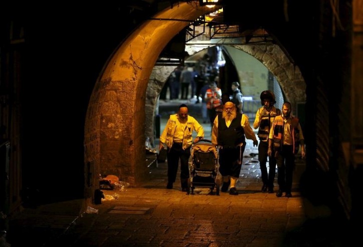 Israeli members of the Zaka Rescue and Recovery team push a baby carriage near the scene where a Palestinian was shot dead after he stabbed and killed two people in Jerusalem's Old City October 3, 2015. A Palestinian man stabbed and killed two people in Jerusalem's Old City on Saturday before police shot him dead, officers said, amid an uptick in violence in the city and occupied West Bank. Palestinian militant group Islamic Jihad issued a statement claiming the attacker as one of its members. REUTERS/Ammar Awad -