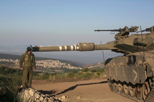 FILE - An Israeli soldier adjusts sights on a tank in the Israeli-occupied Golan Heights, near the ceasefire line between Israel and Syria, June 17, 2015. REUTERS