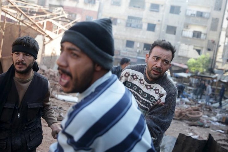 Men react as they carry the remains of dead people at a damaged site hit by missiles fired by Syrian government forces on a busy marketplace in the Douma neighborhood of Damascus, Syria October 30, 2015. Reuters