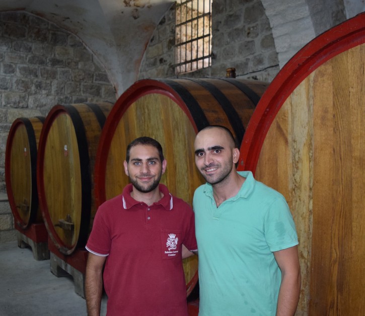 This September 2015 photo shows Fadi Batarseh, an agricultural specialist, and Laith Kokaly, a winemaker, in the Cremisan Winery cellar in Bethlehem. The winery uses local grapes to make fine wines at the site of an ancient church and also hosts tours. Local Palestinian Christians and Muslims work together in the vineyards. (Kevin Begos via AP)