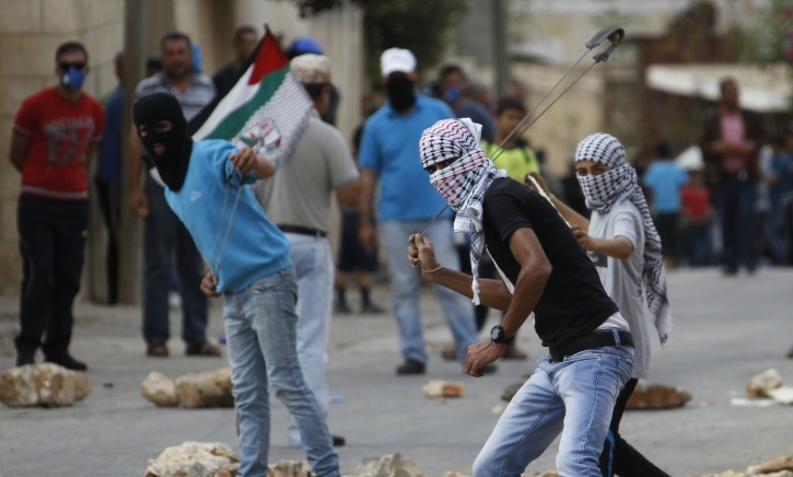  Palestinian protesters hurl stones at Israeli soldiers following a protest against Israeli settlements in Qadomem, Kofr Qadom village, near the the West Bank city of Nablus, 23 October 2015. EPA