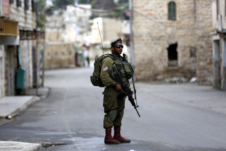 An Israeli border guard soldier patrols close to a checkpoint near the Ibrahimi mosque in the flashpoint West Bank city of Hebron, 30 October 2015.