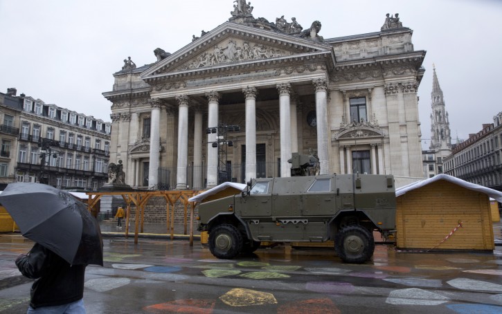 A man walks by a military vehicle in front of the old stock exchange in the center of Brussels on Saturday, Nov. 21, 2015. Belgium raised its security level to its highest degree on Saturday as the manhunt continues for extremist Salah Abdeslam who took part in the Paris attacks. The security levels shut down all metro lines and shuttered many shops as well as canceling sports matches. (AP Photo/Virginia Mayo)