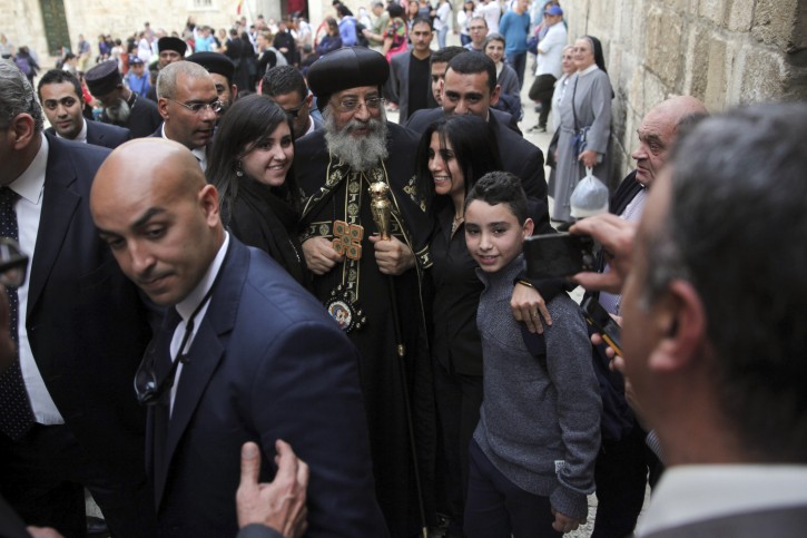 The leader of Egypt's Coptic Orthodox Church Pope Tawadros II poses with faithful in Jerusalem, Saturday, Nov. 28, 2015. Tawadros  traveled with a delegation of senior bishops to attend the funeral of Coptic Archbishop Abraham of Jerusalem despite a ban on pilgrimages to Israel issued by his predecessor, the late Shenouda III, who opposed the normalization of ties between Egypt and Israel. (AP Photo/Mahmoud Illean)