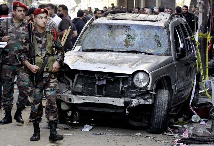 FILE - In this Friday, Nov. 13, 2015 file photo, Lebanese army soldiers stand guard near the damaged car of the family of Haidar Mustafa a three-year-old who was wounded in Thursday's twin suicide bombings, in Burj al-Barajneh, southern Beirut, Lebanon. Within hours of the Paris attacks last week that left 129 dead, outrage and sympathy flooded social media feeds and filled the airwaves.  (AP Photo/Bilal Hussein, File)