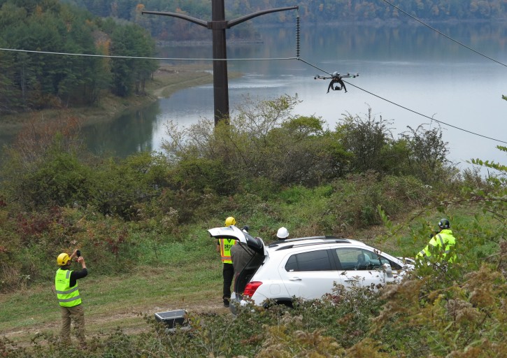 In a Wednesday, Oct. 21, 2015, photo, personnel from Boulder, Colo.-based bizUAS Corp. demonstrate the use of a Cyberhawk octocopter drone for power line inspections at a New York Power Authority hydroelectric generating site in the Catskills, near Blenheim, N.Y.  (AP Photo/Mary Esch)