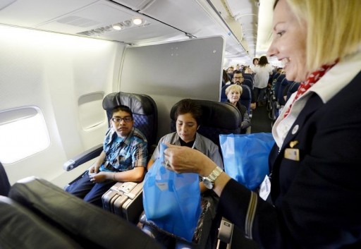 FILE - An American Airlines flight attendant distributes sandwiches aboard an American Airlines plane at Los Angeles International Airport in Los Angeles, California April 18, 2015.REUTERS