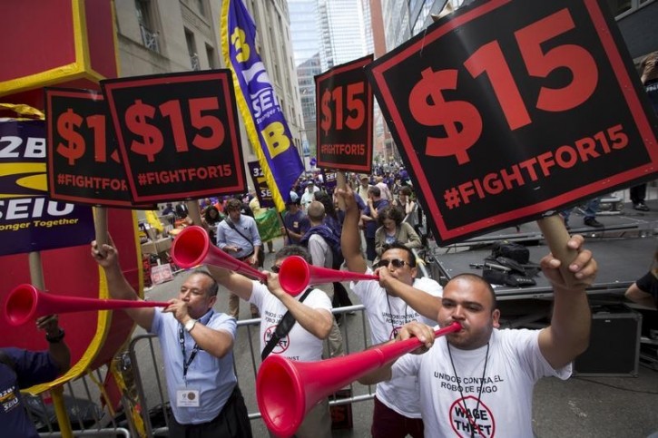 FILE - People celebrate the passage of the minimum wage for fast-food workers by the New York State Fast Food Wage Board during a rally in New York July 22, 2015.   Reuters