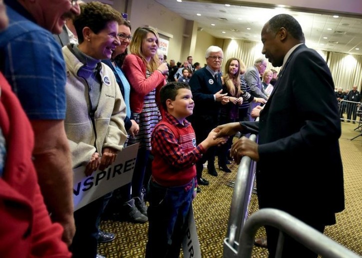 U.S. Republican presidential candidate Ben Carson (R) greets a young supporter after speaking at a campaign event in Pahrump, Nevada November 23, 2015.  REUTERS/David Becker 