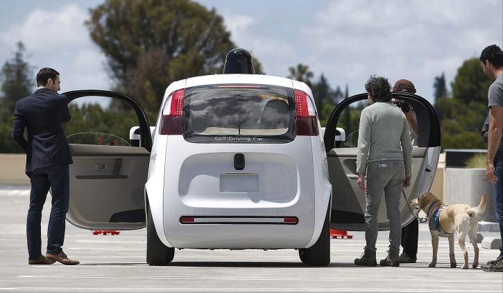 FILE - In this  May 13, 2015, file photo, riders enter the Google's new self-driving prototype car for a ride during a demonstration at Google campus, in Mountain View, Calif. Federal transportation officials say they are updating their position on self-driving cars, with a goal of getting the emerging technology into the publics hands sooner than later. (AP Photo/Tony Avelar, File)