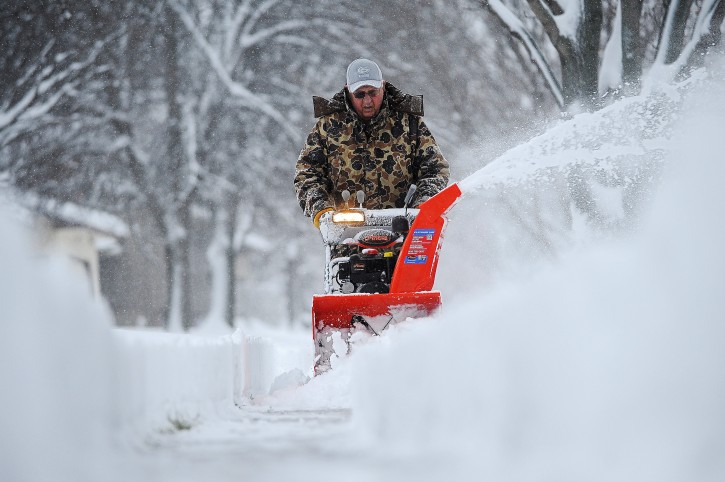 Harvey Wollman, of Sioux Falls, uses a snow blower to clear the sidewalk near his house during the first snow of the season Friday, Nov. 20, 2015, in Sioux Falls, S.D. (Joe Ahlquist/The Argus Leader via AP)