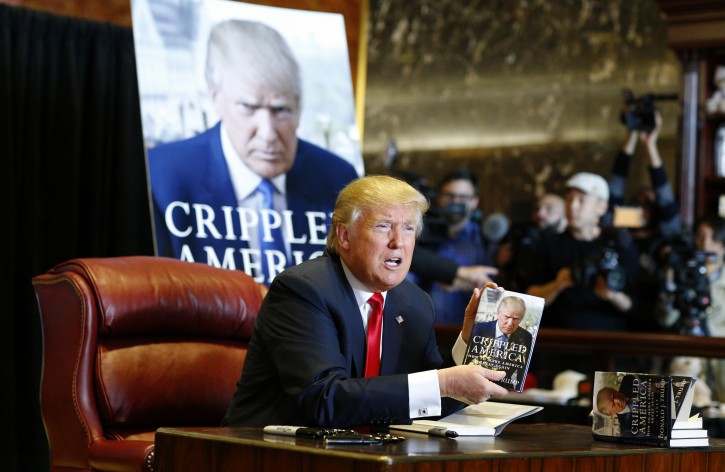 Republican US presidential candidate Donald Trump signs copies of his new book 'Crippled America' at the Trump Building in New York, New York, USA, 03 November 2015.  EPA/ANDREW GOMBERT