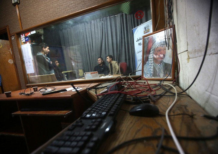  Palestinian journalists inspect the damage of the Al-Khalil radio station in the West Bank city of Hebron, 21 November 2015. EPA