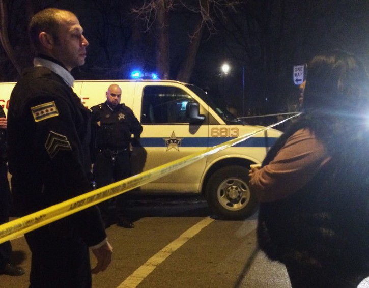 A Chicago police sergeant speaks with a relative of a man who was killed by a police officer in the West Garfield Park neighborhood in Chicago, early Saturday, Dec. 26, 2015. A Chicago police officer shot and killed two people while responding to a domestic disturbance call in the neighborhood on the city's West Side, police said. (Megan Crepeau/Chicago Tribune via AP)