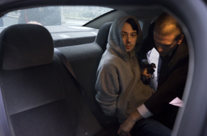 Martin Shkreli, the former hedge fund manager under fire for buying a pharmaceutical company and ratcheting up the price of a life-saving drug, is belted into an awaiting car after being taken into custody following a securities probe, on Thursday, Dec. 17, 2015 in New York. A seven-count indictment unsealed in Brooklyn federal court Thursday charged Shkreli with conspiracy to commit securities fraud, conspiracy to commit wire fraud and securities fraud. (AP Photo/Craig Ruttle)