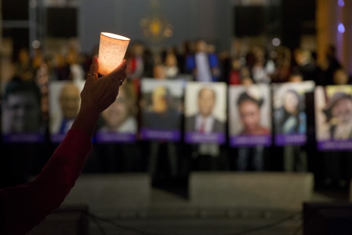 FILE - In this Dec. 7, 2015, file photo, Arlene Payan holds a candle during a vigil to honor shooting victims in San Bernardino, Calif. The shootings in San Bernardino are a reminder of how vulnerable workplaces can be. (AP Photo/Jae C. Hong, File)