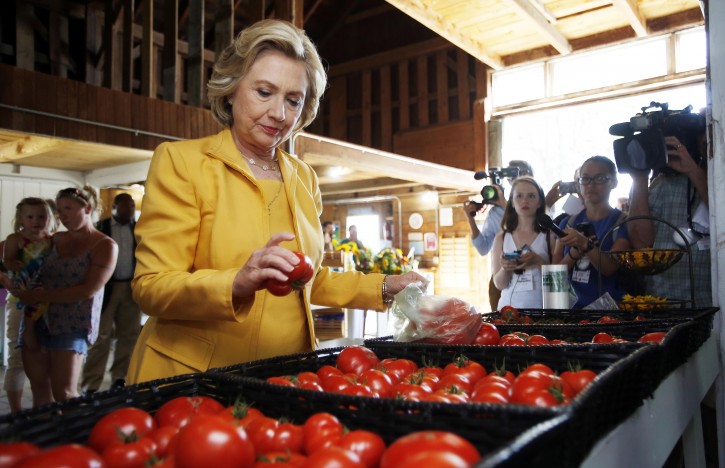 FILE - In this July 28, 2015, file photo, Democratic presidential candidate Hillary Clinton gets fresh tomatoes at Dimond Hill Farm between campaign stops in Hopkinton, N.H. Clinton knows from three previous trips down the presidential campaign trail, politicking means picking your food carefully. Since launching her campaign bid in April, Clinton has embarked on a rigorous diet plan, hoping to stave off the pounds that often accompany the near-sleepless nights and non-stop snacking of a campaign. (AP Photo/Jim Cole, File)